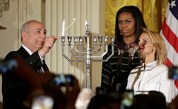 בנו ונכדתו של שמעון פרס ז''ל מדליקים חנוכיה (רויטרס)