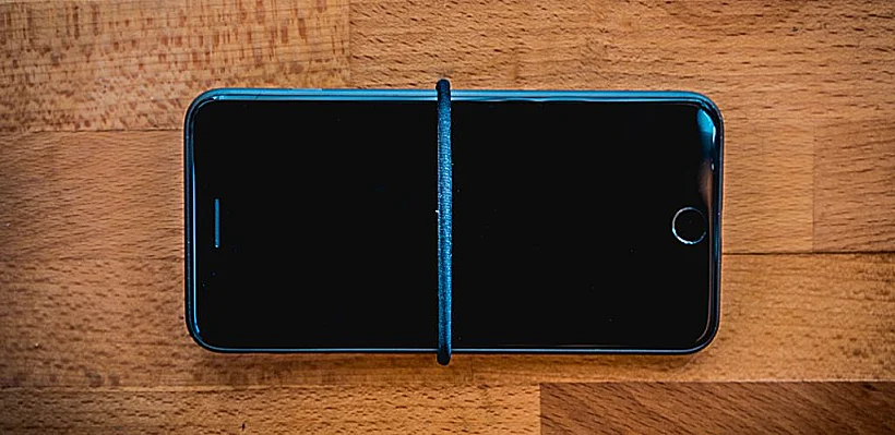 קחו גומייה לשיער ועטפו את המכשיר שלכם, כך שיעבור בדיוק במרכז המסך