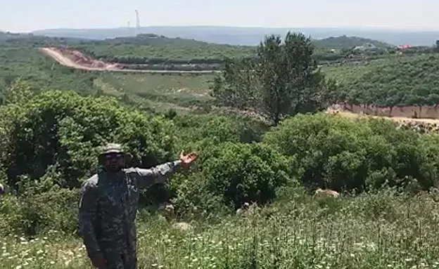 סיור ההסברה של חיזבאללה. איש חיזבאללה על גדר הגבול (ארכיון)