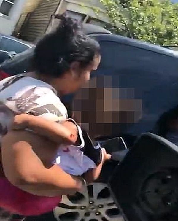 האישה מוציאה את בתה הפצועה מהרכב
