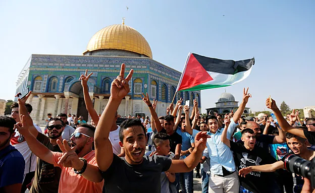 מתפללים חוגגים על רקע הסרת אמצעי הבידוק (רויטרס)