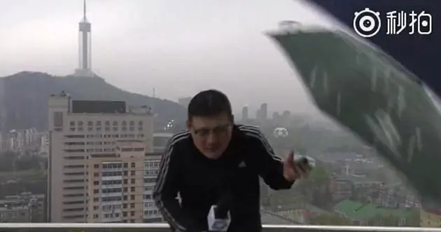 החזאי שיאודונג זורק את המטריה שניות לאחר הפגיעה