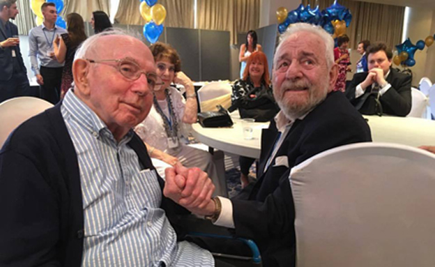 בני המשפחה עם העץ המשפחתי הענק במפגש בלונדון
