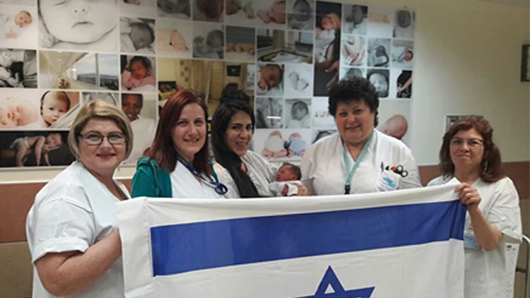 אחיות מחלקת יולדות עם האם והתינוקת העצמאות. תינוקת ראשונה לשנת ה-70 למדינת ישראל