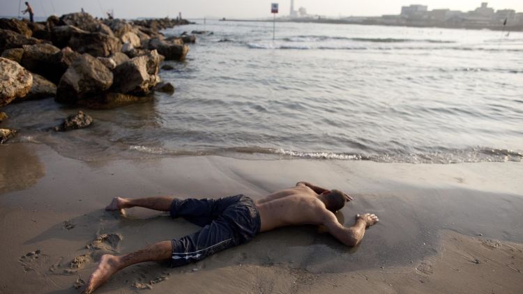 ישראלי על החוף בתל אביב במהלך גל חום קיצוני