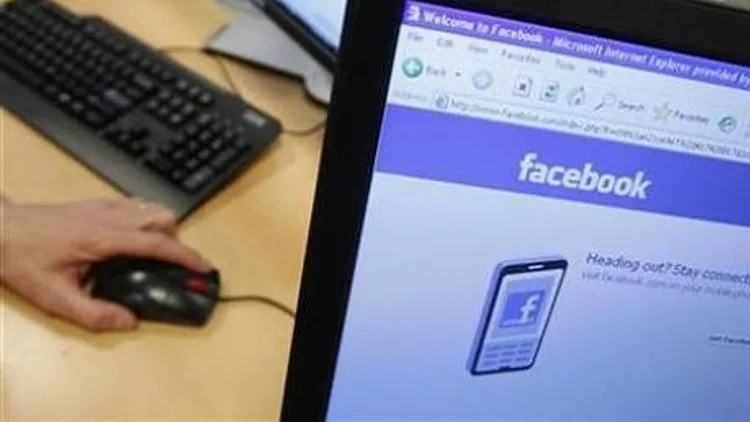 מסך מחשב ובו פייסבוק, כשברקע מקלדת ועכבר