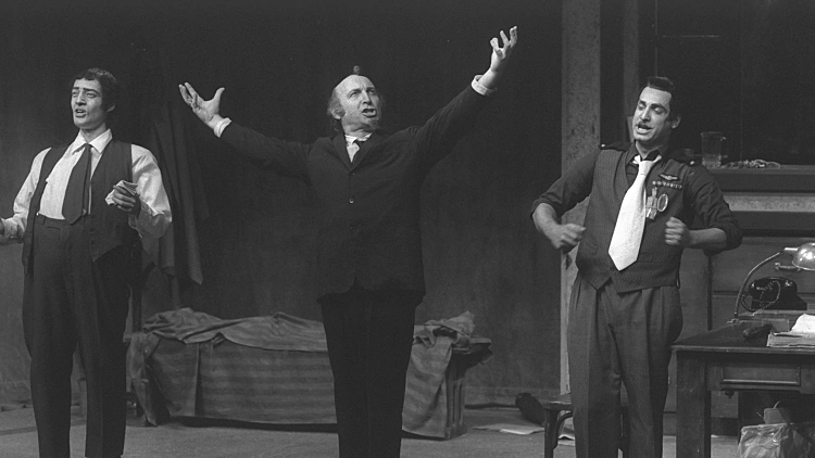 השחקן יהודה אפרוני ב-1982 בהצגה "חקירה חוזרת בדבר מותו של אנרכיסט מפוקפק"