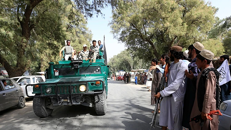 כוחות הביטחון האפגניים רוכבים על רכב צבאי במהלך הפסקת האש ברובע באטי קוט במחוז נאנגרהאר, אפגניסטן