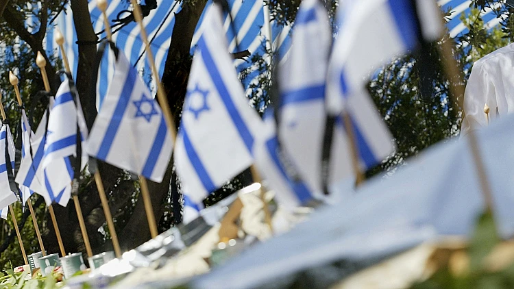 דגלי ישראל בבית עלמין צבאי ביום הזיכרון