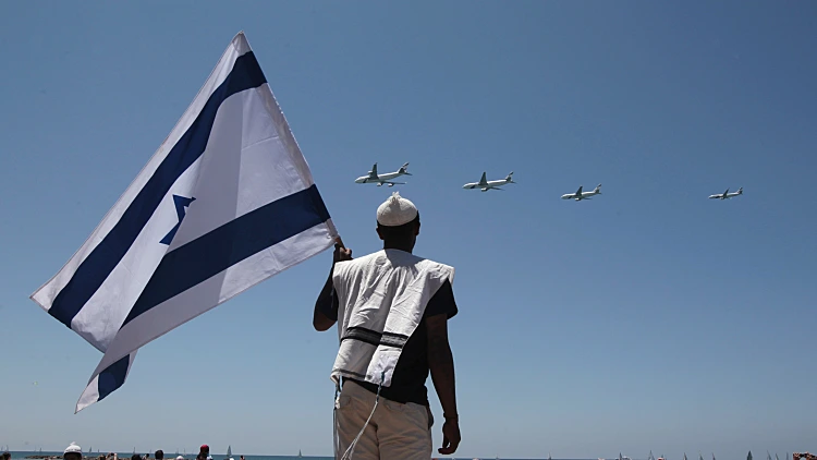 אנשים צופים במטס בחוף בתל אביב ביום העצמאות