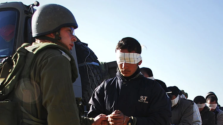 חייל צה"ל ליד אסירים פלסטינים שנעצרו במהלך פעולת צה"ל בצפון רצועת עזה