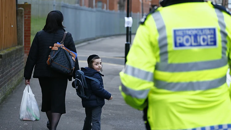 ילד יהודי הולך בלונדון ליד בית ספר מאובטח