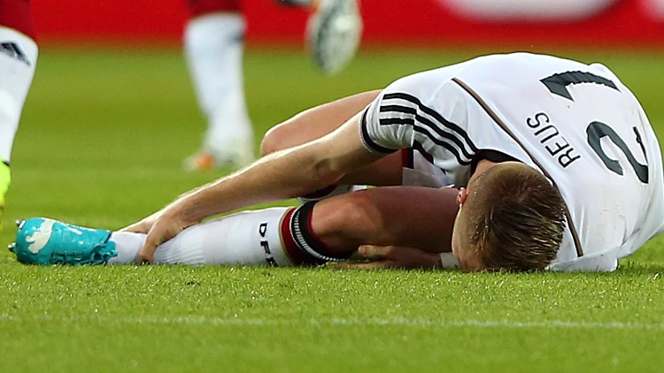 מרקו רויס, חלוץ נבחרת גרמניה, שרוע על הדשא לאחר פציעה במשחק נגד ארמניה