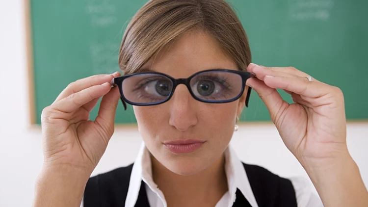 תלמידה חנונית מחזיקה משקפיים