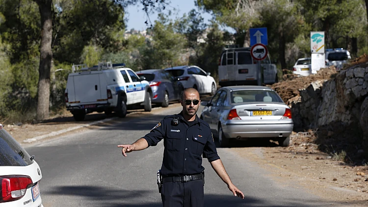 שוטר מכוון את התנועה ליד זירת מציאת גופת הנער הפלסטיני ביער ירושלים