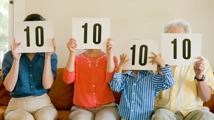 ארבעה בני משפחה משלושה דורות מרימים את המספר 10 כמו צוות שופטים בתחרות על שלטים שהם מציבים מול הפנים שלהם