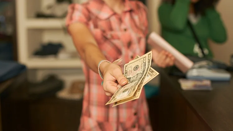אישה מחזיקה דולרים