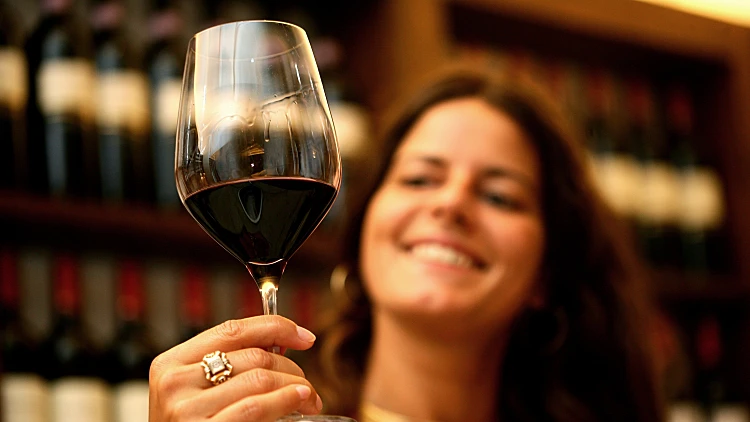 אישה מחזיקה כוס יין