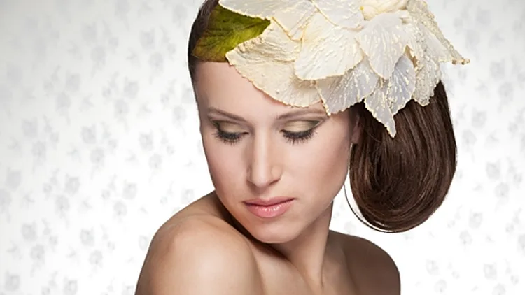 אשה מושכת עטורה בכובע בצורת פרח