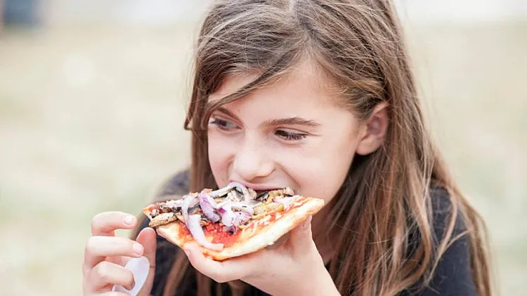 ילדה אוכלת פיצה