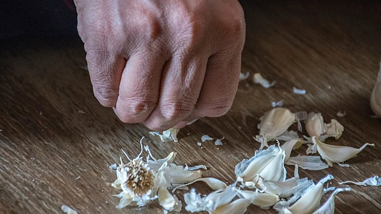 Stock,photo,of,a,women,hand,peeling,raw,garlic,which