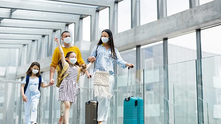 Family,with,two,children,going,on,holiday,,wearing,face,masks