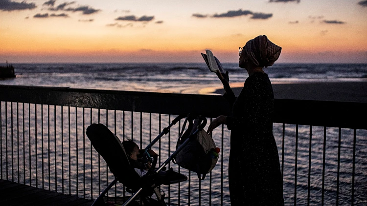 אישה עורכת תשליך ליד הים בתל אביב