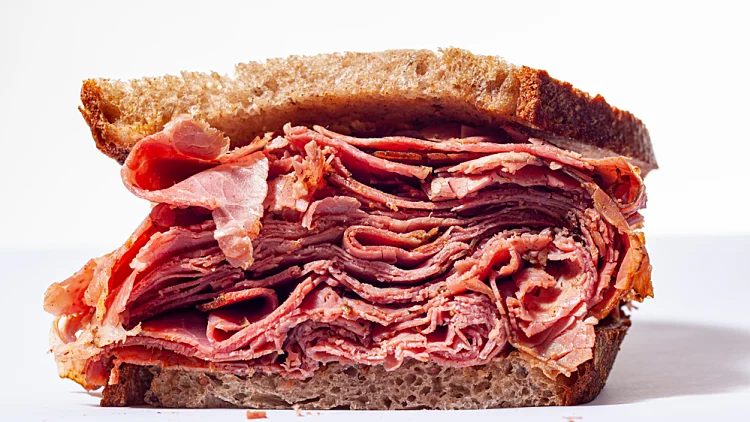 Large,pastrami,sandwich,piled,high,with,meat.