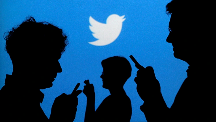 File Photo: People Holding Mobile Phones Are Silhouetted Against A Backdrop Projected With The Twitter Logo In Warsaw