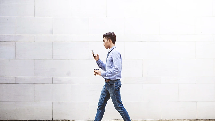 Young,motivation,businessman,use,smart,phone,while,walk,outdoor,building,