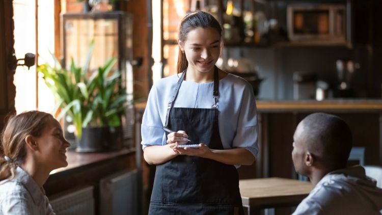 Waitress Welcoming Restaurant Guests Take Order Writing On Notepad