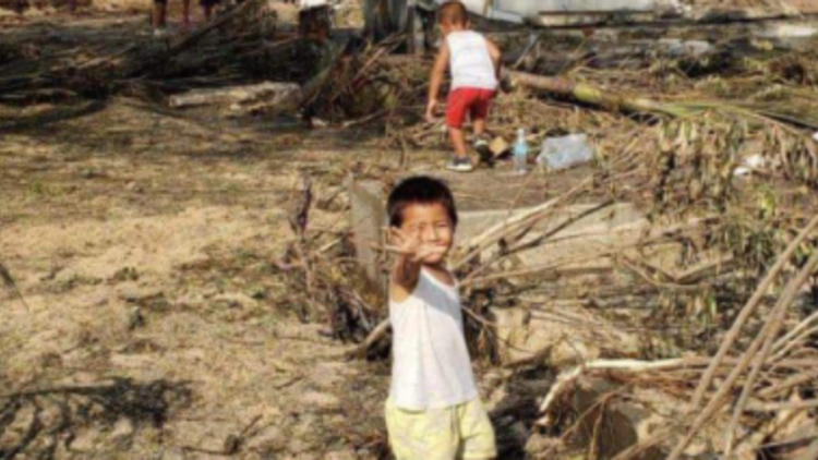 ילד על רקע ההרס באיי טונגה