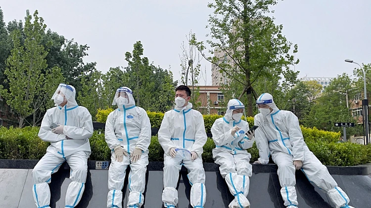 עובדים בחליפות מגן ליד מתחם בדיקות קורונה בבייג'ינג