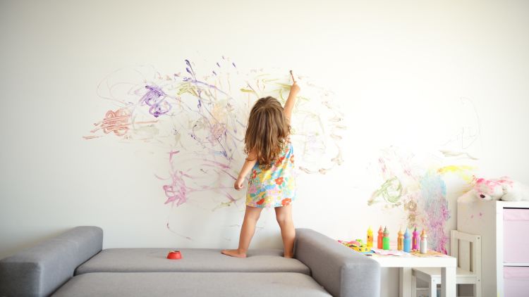 ילדה צובעת את הקיר