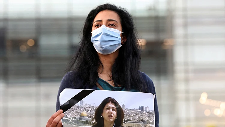עיתונאית לבנונית מחזיקה תמונה של שירין אבו עאקלה מול בניין האו"ם בביירות