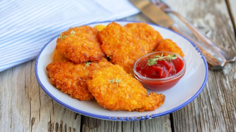 Little,chicken,schnitzel,on,beautiful,plate,with,ketchup.,on,wooden