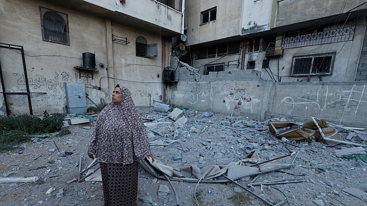אישה בעזה ליד ההריסות בעקבות הפצצת הבניין שבו שהה בכיר הג'יהאד שחוסל