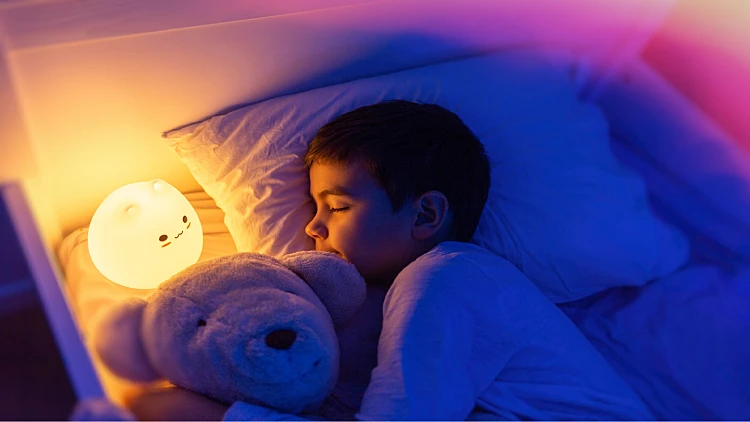 ילד ישן עם מנורת לילה
