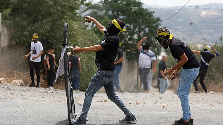 פלסטינים מיידים אבנים לעבר חיילי צה"ל במהלך הפרות סדר ביהודה ושומרון