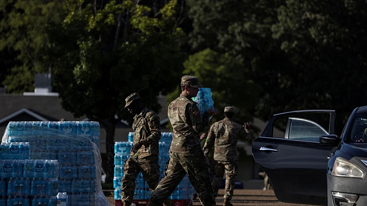 אנשי המשמר הלאומי נושאים בקבוקי מים לחלוקה בג'קסון, מיסיסיפי