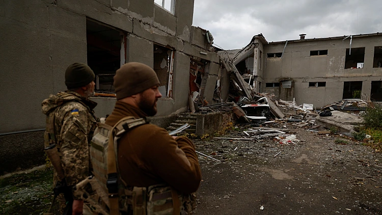 חיילים אוקראינים ליד בית ספר שנהרס בהפגזות רוסיות במיקולאייב