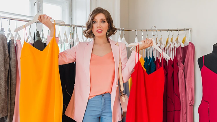 Emotional,attractive,happy,woman,holding,colorful,dresses,in,clothing,store,