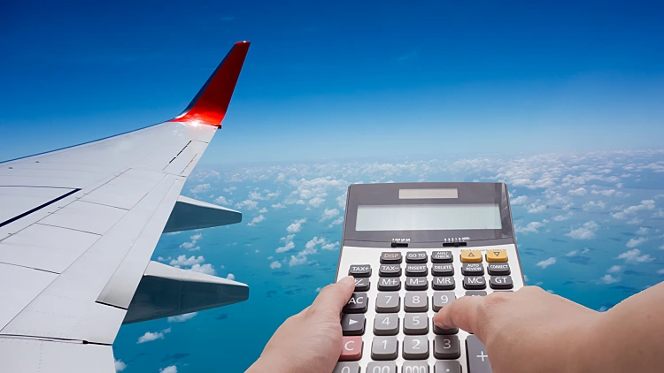 Travel,cost,calculation,concept,by,calculator,and,airplane,in,background