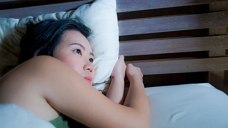 Woman lying awake in bed, unable to sleep