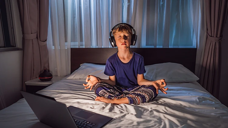 Boy,meditates,on,bed,using,meditation,app.,sport,,technology,and