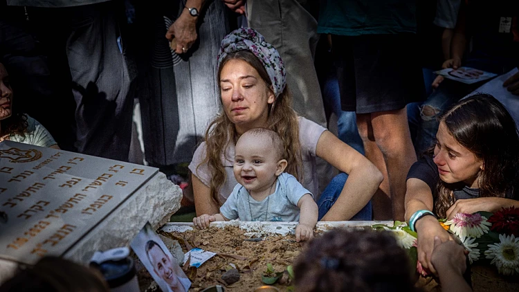 האלמנה שבנה התינוק צולם מחייך על קבר אביו: "אספר לו מי היה אבא"