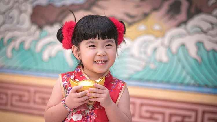 China,girl,in,traditional,chinese,dress,greeting,,holding,a,gold