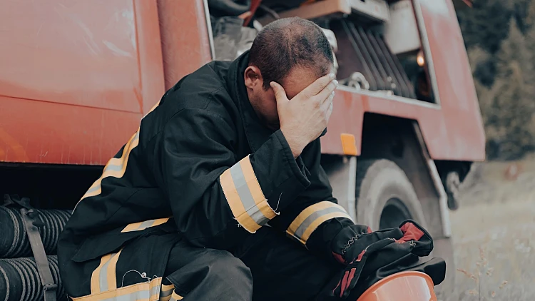 Depressed,and,tired,firefighter,near,fire,truck.