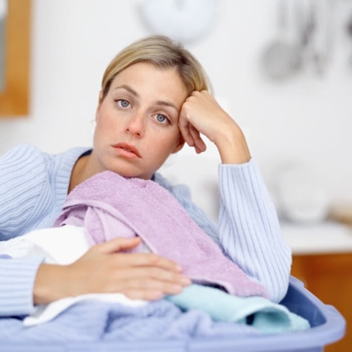 אישה עם כביסה במבט עייף