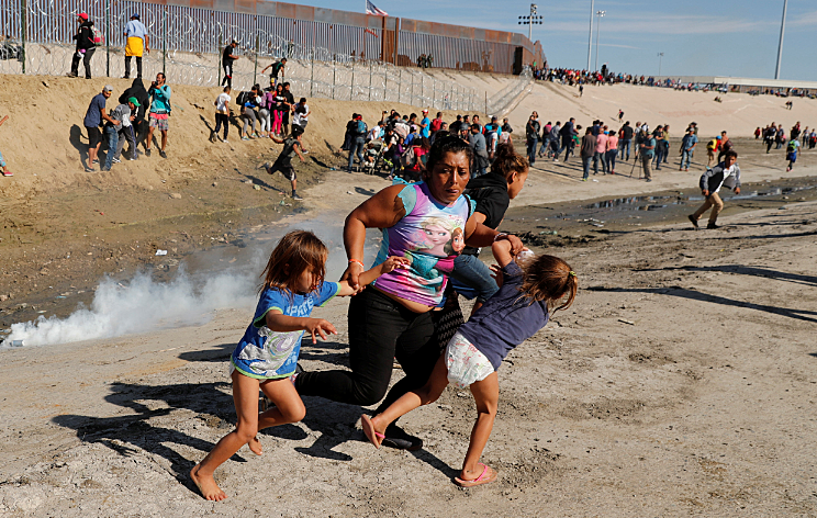 אם וילדיה נמלטים מגז מדמיע בגבול מקסיקו